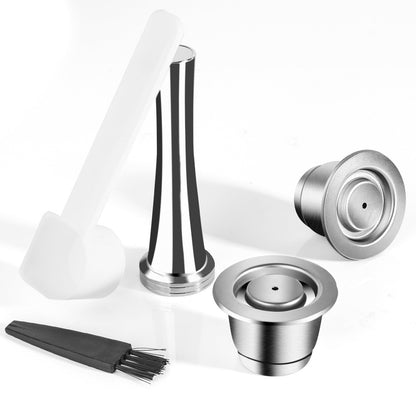 Two stainless steel coffee capsules with accompanying tamper. All on a white background. Includes a free brush and scoop.